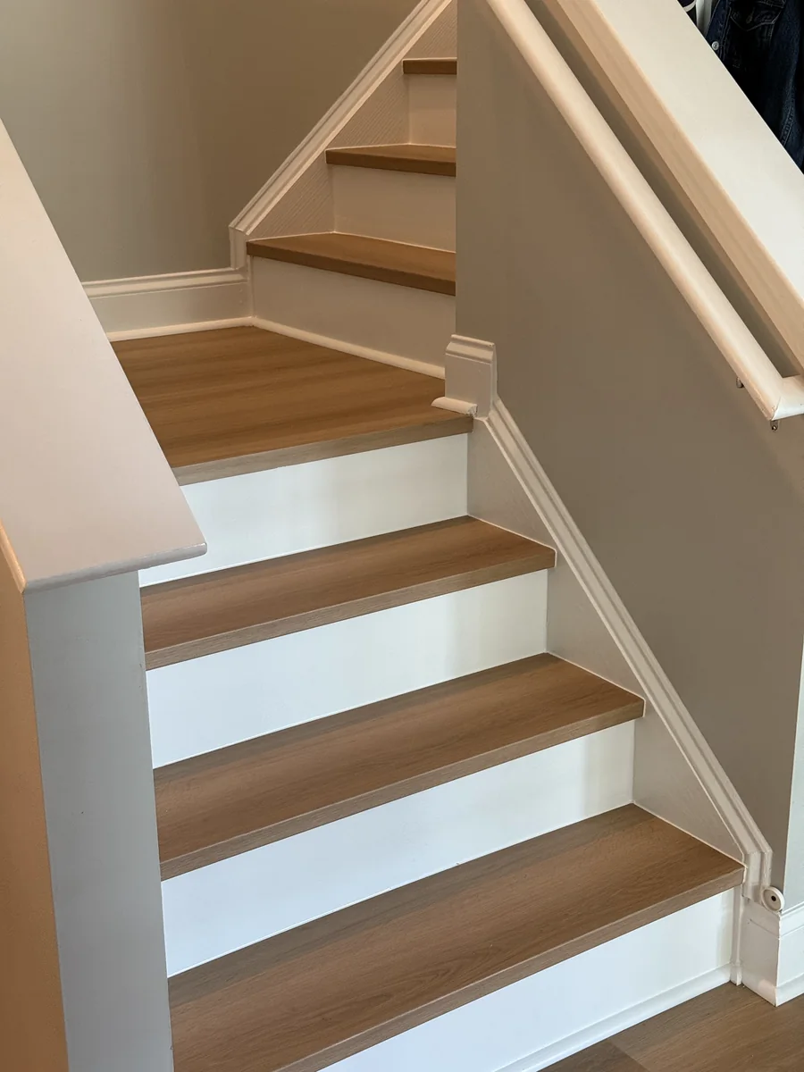 Light oak treads and white risers on a turning staircase, matched to the floor below