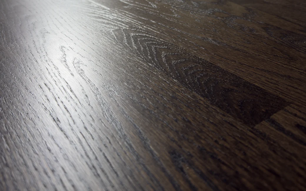 Close-up of newly installed oak flooring meeting the baseboard